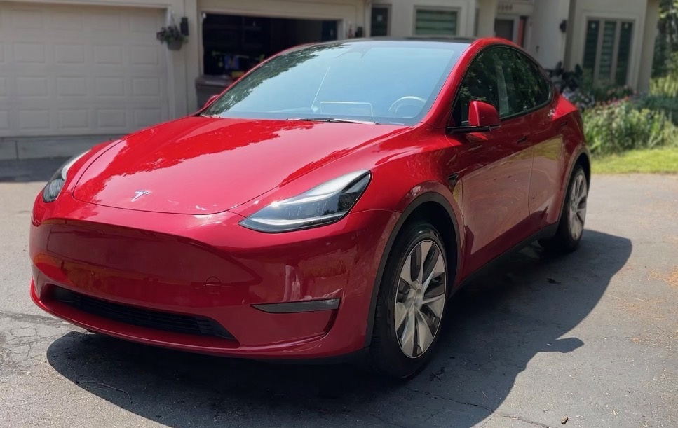 Freshly detailed red Tesla Model Y in a driveway